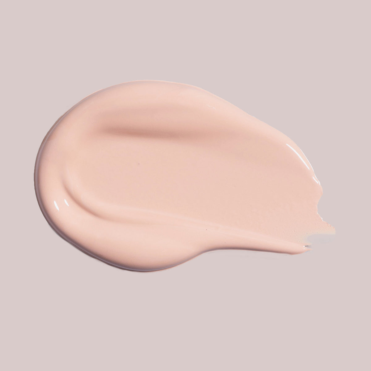 Ein Klecks Wide Awake Full Coverage Concealer Cafe con Leche in Hellbeige auf einem blassen Hintergrund.