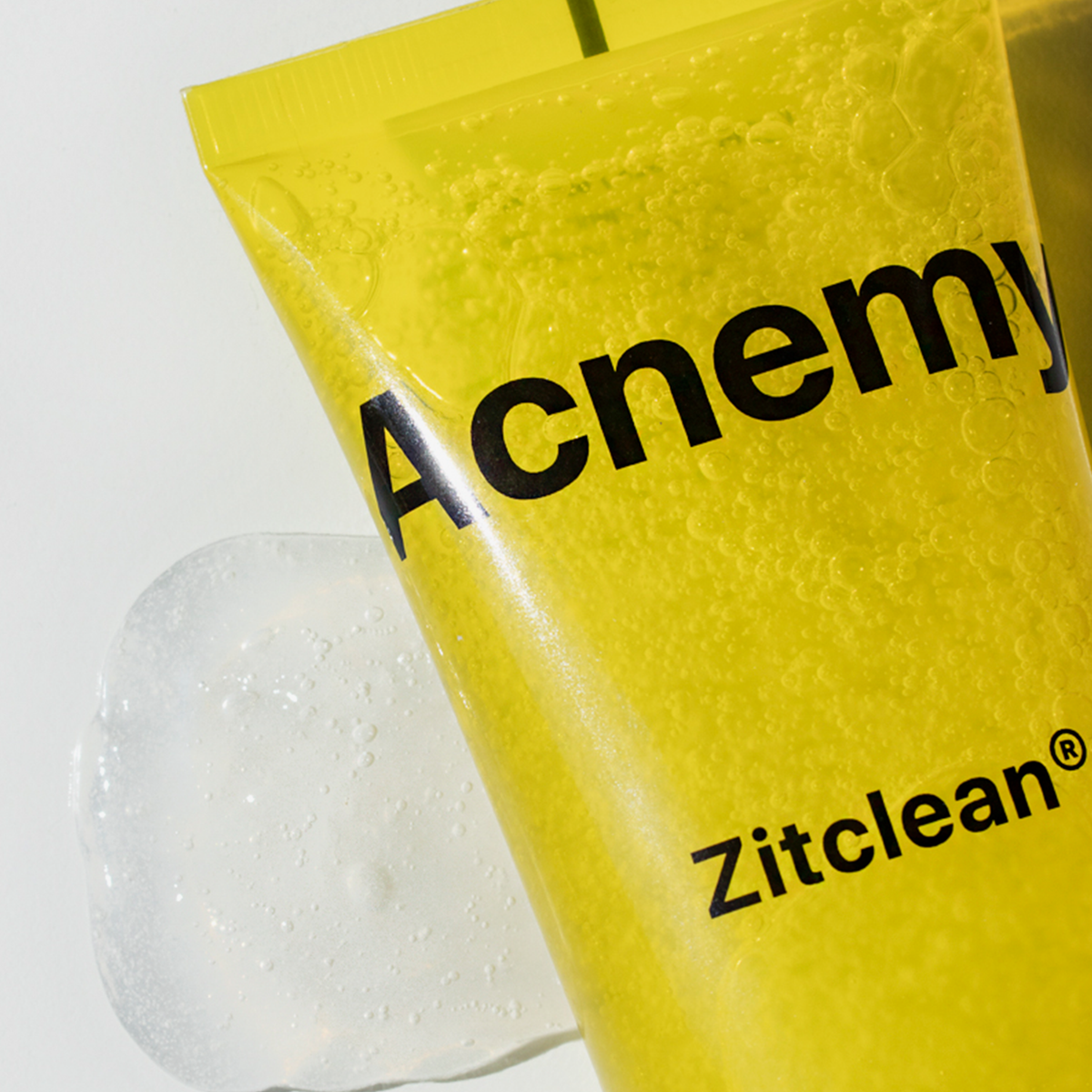 Teil einer Acnemy Zitclean® Tube auf weißem Grund mit einem Klecks Produkt