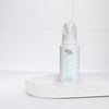 Eine Flasche Pure Tanning Face Mist von Bondi Sands steht auf einem gesprenkelten weißen Tablett in minimalistischem Ambiente