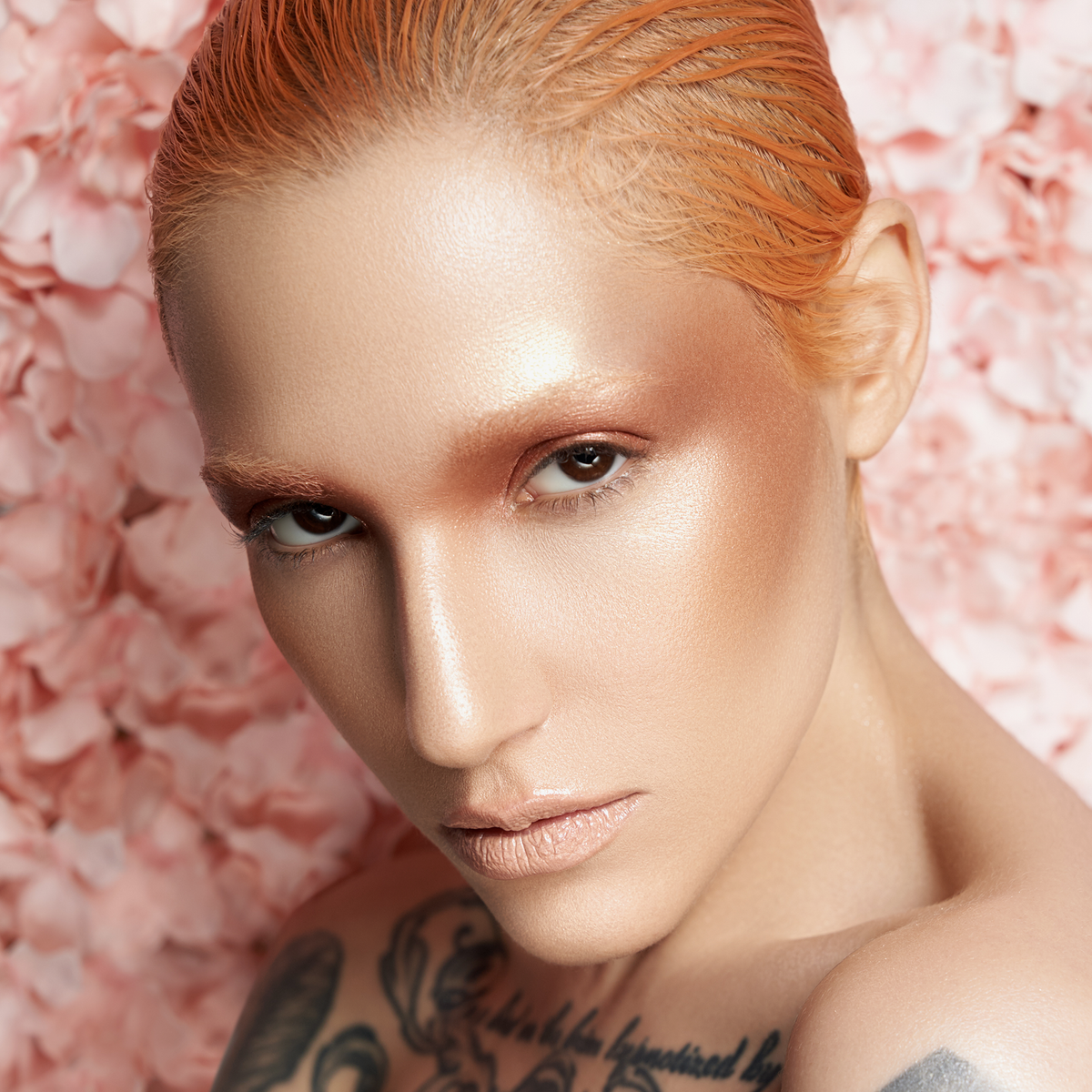 Eine Person mit strahlendem Make-up aus der Waterproof Cream Palette Essentials und zurückgekämmtem orangefarbenem Haar.