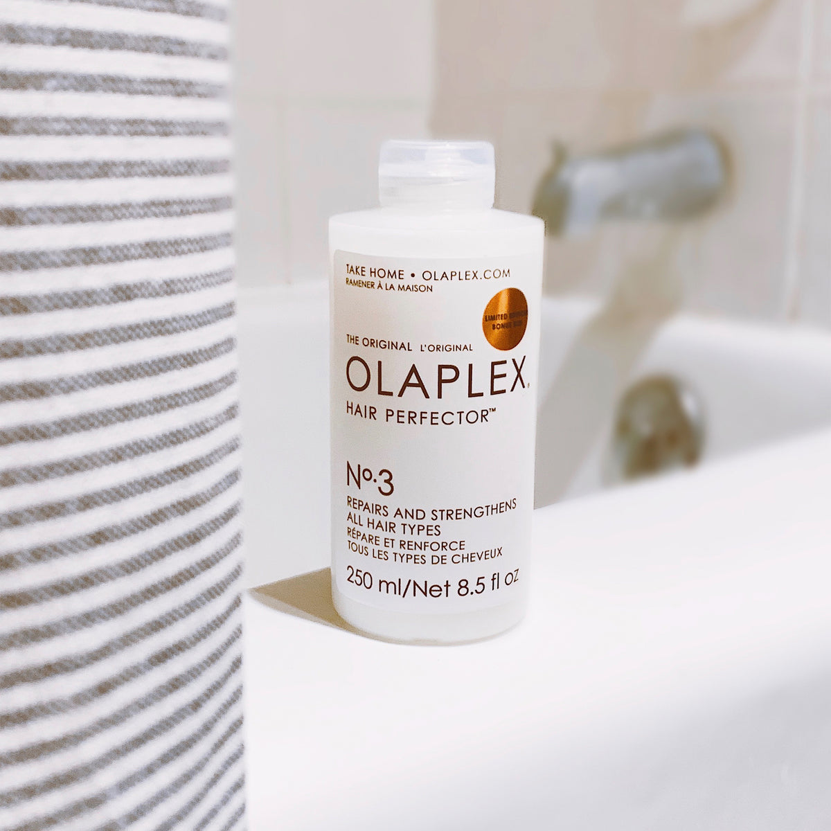 OLAPLEX No.3 Hair Perfector 250ml auf einem Badewannenrand.