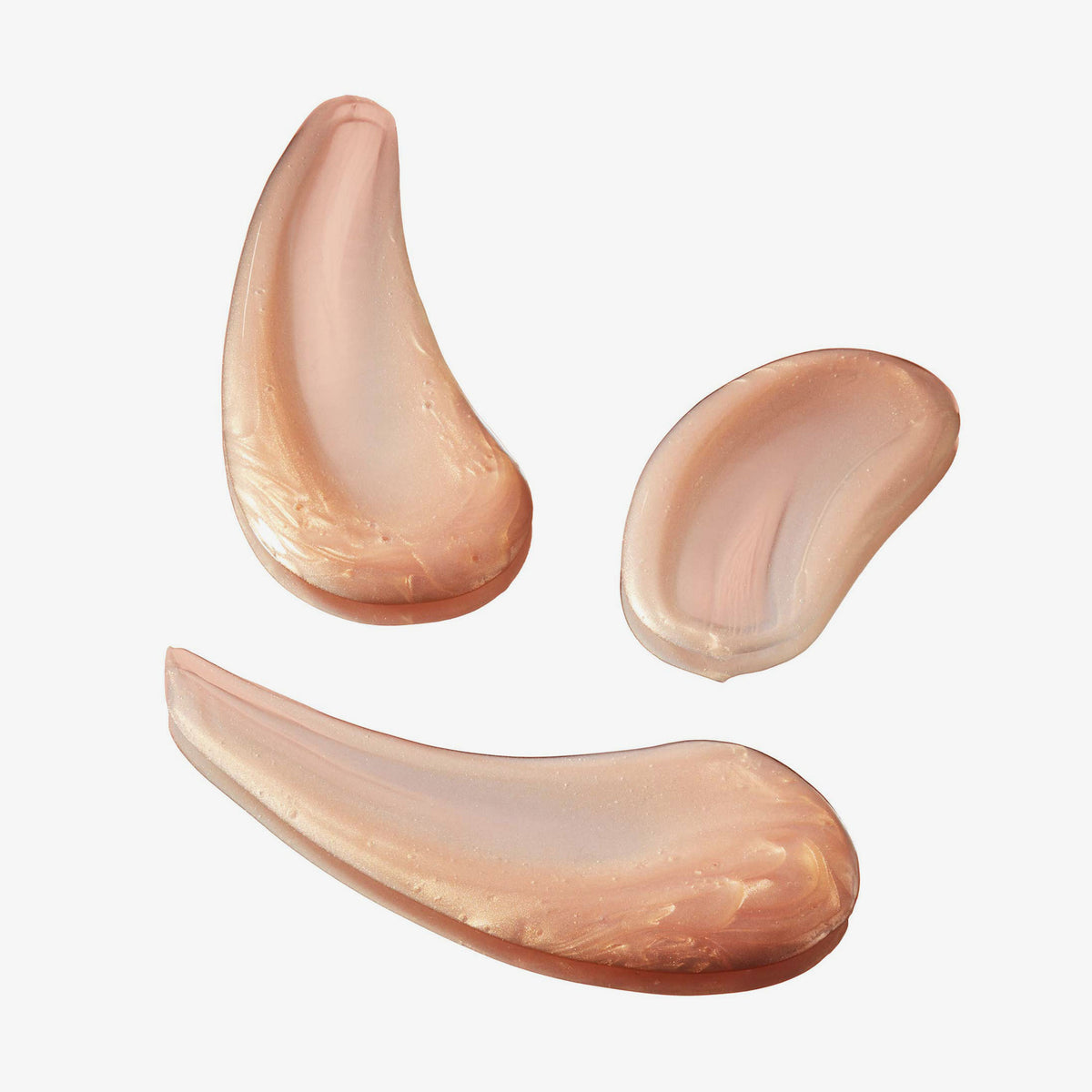 Drei Kleckse schimmerndes Angel Aura Produkt auf weißem Hintergrund.