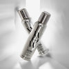Zwei silberne Dosen Extra Shine Spray sind in X-Form auf weißem Hintergrund angeordnet.