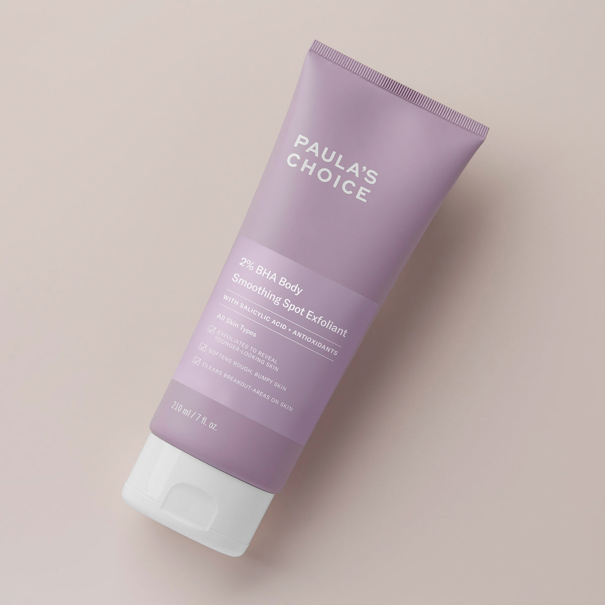 Eine Tube 2 % BHA Body Spot Exfoliant auf hellbeigem Hintergrund.