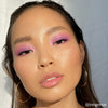 Person mit rosa Make-up Look aus der 16-Color-Lidschattenpalette „Lost in Los Angeles“ blickt in die Kamera
