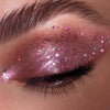 Ein geschlossenes Auge zeichnet sich durch lange, dunkle Wimpern und rosa Schimmer aus der Glorious Lights Glitter Palette aus.