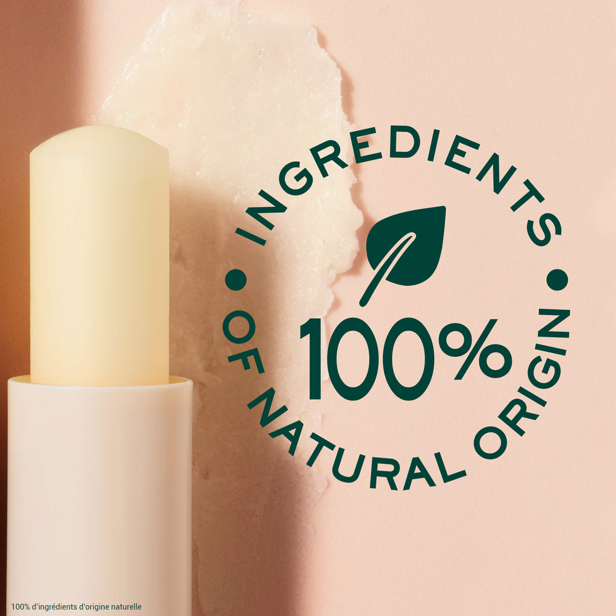 NUXE Lippenpflegestift vor rosa Hintergrund mit aufgetragener Textur. Daneben ein rundes Siegel mit der Aufschrift: ‚100 % Ingredients of Natural Origin‘.