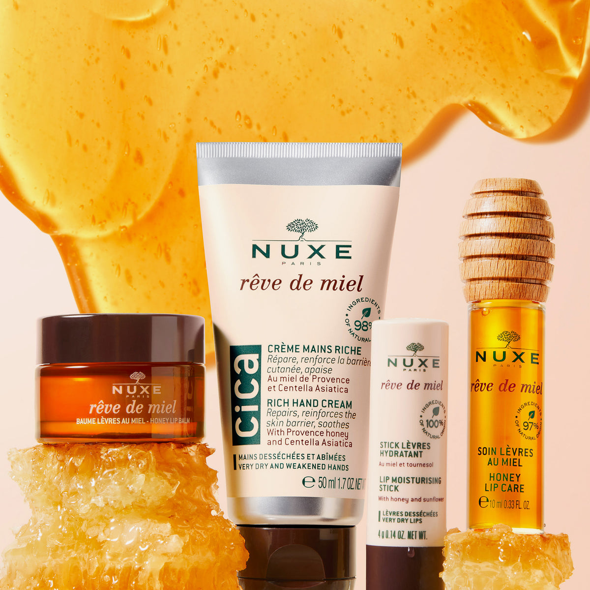 Vier Nuxe Rêve de Miel Pflegeprodukte vor Honighintergrund: Lip Balm, Handcreme, Lippenpflegestift und Lip Care mit Holzapplikator.