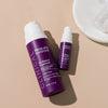Zwei Flaschen Clinical 1 % Retinol Treatment werden auf einer beigen Oberfläche mit einer weißen Schale präsentiert.
