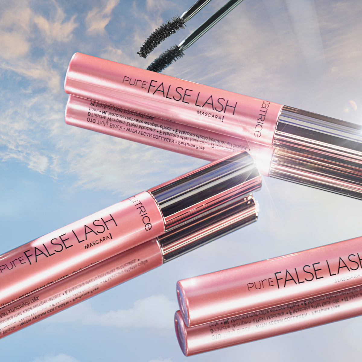 Drei Catrice Cosmetics Pure False Lash Mascara 010 liegen auf einem Spiegel der den Himmel reflektiert.