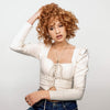Eine Frau mit lockigem rotem Haar zeigt Wirkung des Dream Coat For Curly Hair vor weißem Hintergrund.