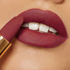 Der Matte Pleasure Lipstick in der Farbe Karma Red auf den Lippen aufgetragen – Nahaufnahme mit samtig-mattem Finish.
