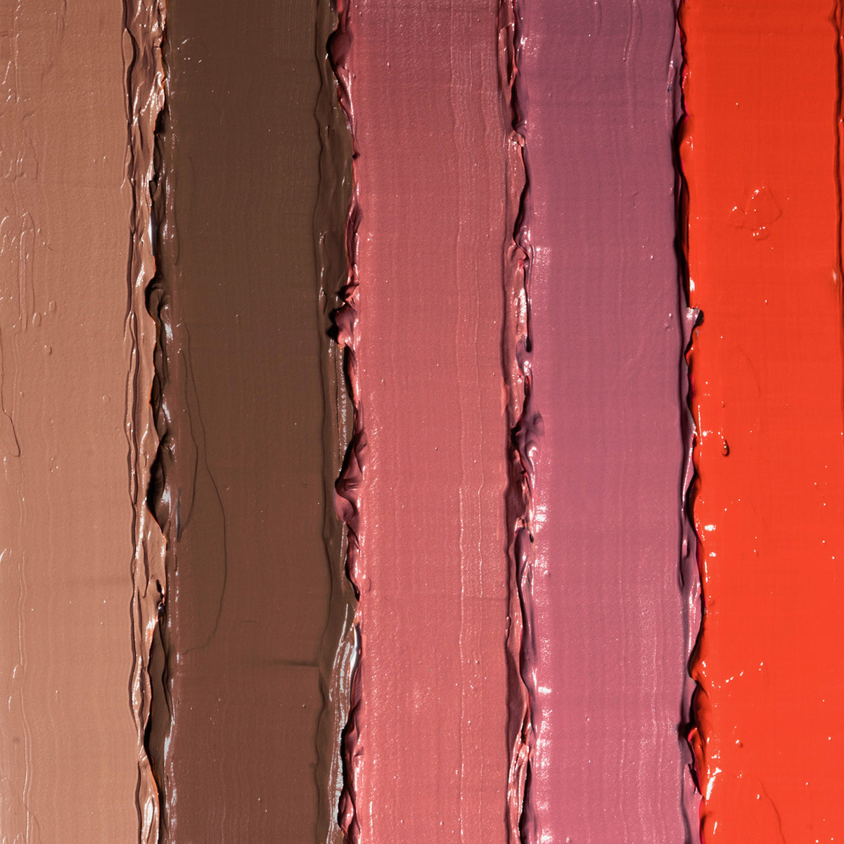 Fünf dicke, vertikale Striche der flüssigen LH Cosmetics Velvet Couture Lippenstifte  in Braun-, Mauve-, Rosa- und Rottönen nebeneinander.