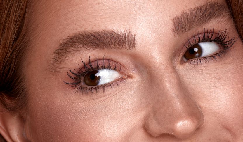 „Nahaufnahme eines Gesichts mit betonten Augen, braunen Augen und definierten Wimpern sowie buschigen, gepflegten Augenbrauen.