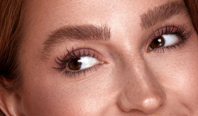 „Nahaufnahme eines Gesichts mit betonten Augen, braunen Augen und definierten Wimpern sowie buschigen, gepflegten Augenbrauen.