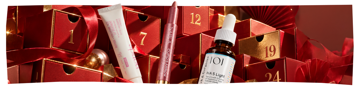 Eine Tube NudeStix-Lippenpflege, ein Nabla-Lippenstift und eine Flasche 101 HA 5 Light-Serum, angeordnet vor roten, nummerierten Adventskalender-Fächern.
