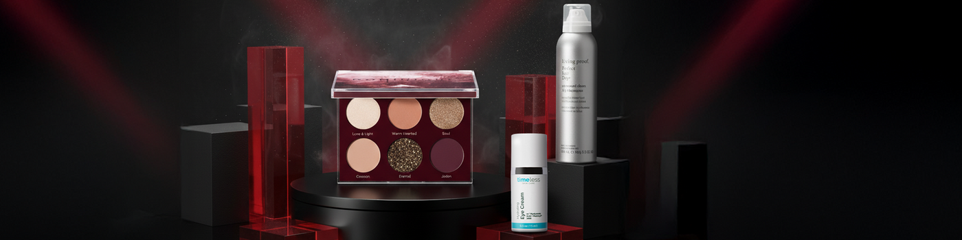 Eine Make-up-Palette, eine silberne Spraydose und eine kleine Hautpflegeflasche auf einem schwarz-roten Hintergrund.