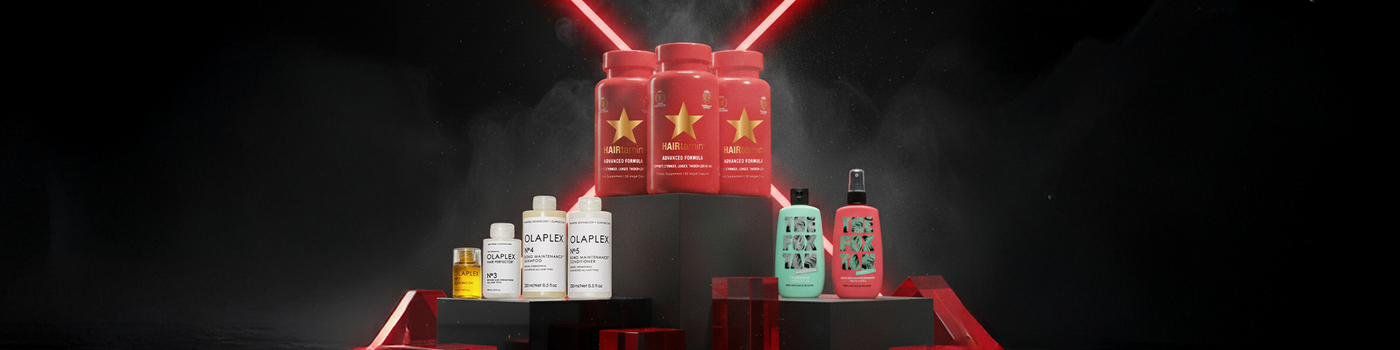 Verschiedene Haarpflegeprodukte werden auf schwarzen und roten Podesten mit roten Lichtern im Hintergrund präsentiert.