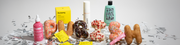Beauty-Produkte und bunte Donuts formen das Wort “PURISH”. Konfetti liegt auf dem Boden – die Szene wirkt verspielt und fröhlich.