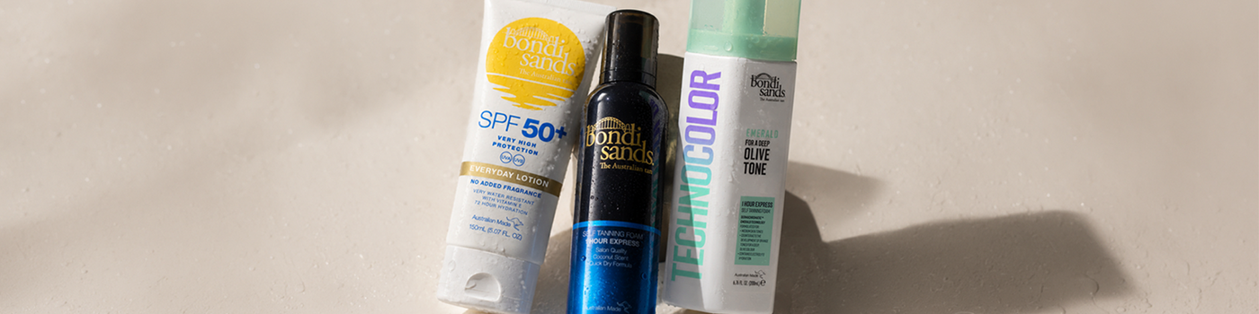 Werbung für Bondi Sands mit drei fröhlichen Frauen in Bademode und Bräunungs- sowie Sonnenpflegeprodukten vor blauem Hintergrund.