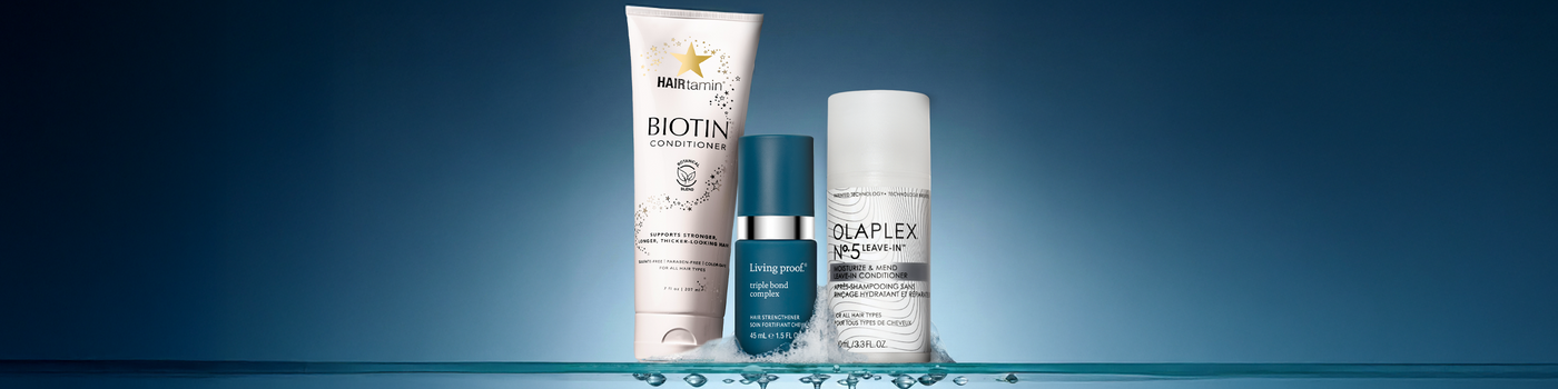 Vier Haarpflegemittelflaschen stehen inmitten flauschiger, pastellfarbener Wolken.