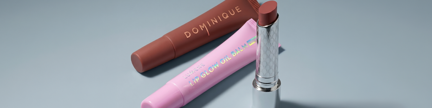 Nahaufnahme einer lächelnden Person, die ein Glas Nuxe Rêve de Miel Honig-Lippenbalsam an die Lippen hält.