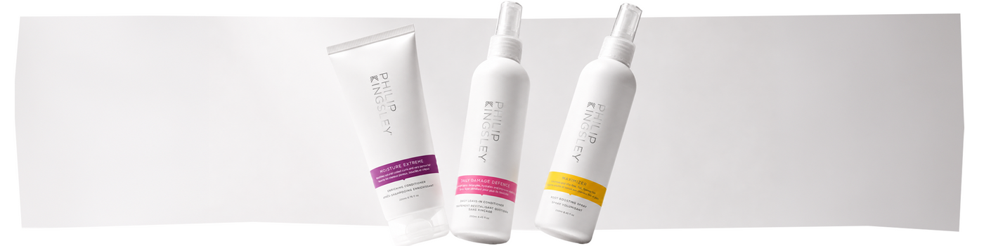Auf einem weißen Hintergrund sind drei Haarpflegeprodukte von Philip Kingsley abgebildet: eine Tube mit einem violetten Etikett und zwei Sprühflaschen mit gelben und rosa Etiketten.