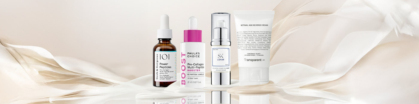 Fünf Serum- und Cremeflaschen und -tuben sind in einer Reihe auf einem weichen, beigefarbenen, wirbelnden Hintergrund angeordnet.