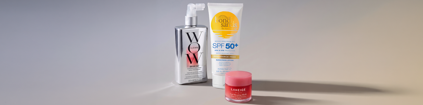 Frau mit dunklen Haaren und Sommersprossen, blickt selbstbewusst in die Kamera, neutraler Hintergrund.