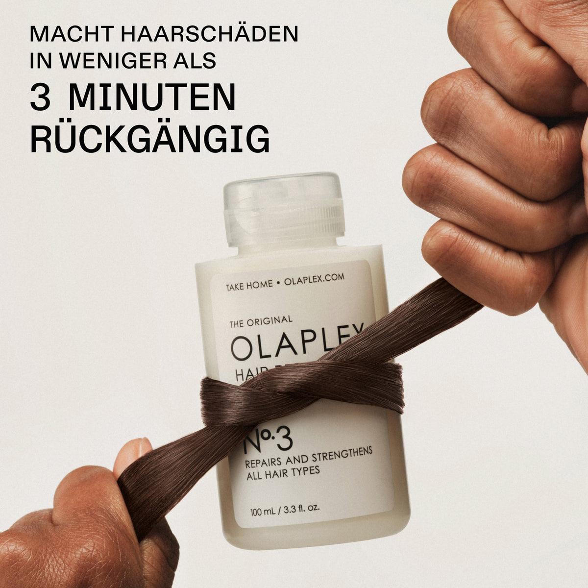 Eine Flasche OLAPLEX N°3 Hair Perfector umknotet von einem braunen Haarstrang; Text besagt: "Macht Haarschäden in weniger als 3 Minuten rückgängig"