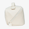 Die PURISH Reisetasche – Cream ist eine kleine, cremefarbene Tasche aus strukturiertem Leder mit einem diagonal verlaufenden Reißverschluss und einem Tragegriff an der Oberseite.