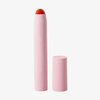Eine rosa BLONDESISTER 2-IN-1-Tube „IT’S UP TO YOU – LIP OR CHEEK“ mit abgenommenem Deckel, in der ein roter Balsam zu sehen ist.