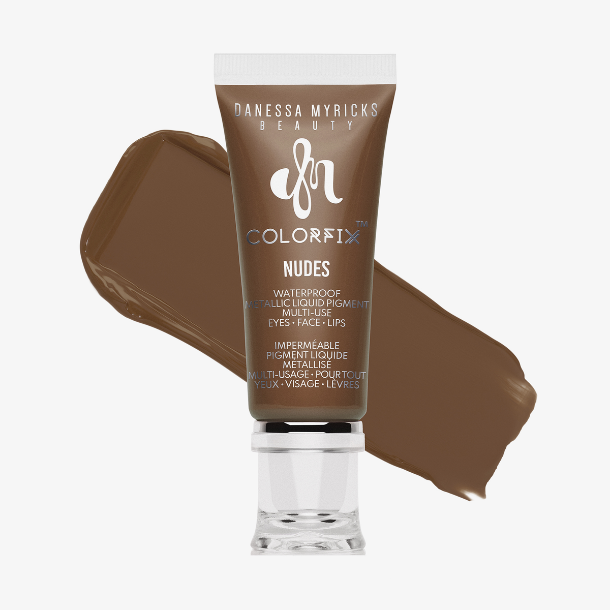 Eine Tube Danessa Myricks Beauty Colorfix Nudes in der Farbe 11 mit einem Klecks des braunen Flüssigpigments dahinter.