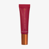 Eine rote Tube „Danessa Myricks Beauty Glosswork 4D Ultra Shine Plumping Gloss“ mit kupferfarbenem Verschluss vor weißem Hintergrund.