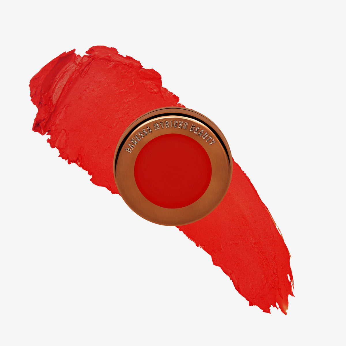 Yummy Skin Blurring Balm Powder Flushed Red Velvet in rundem bronzenem Behälter auf knallrotem Farbmuster abgebildet.