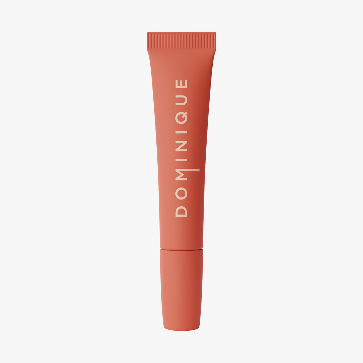 Coral Juicy Lip Balm von Dominique Cosmetics mit geriffelter Kappe, vertikalem DOMINIQUE-Etikett und weißem Hintergrund.
