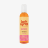 Eine Flasche Hair Syrup Rapunzel Pre-Wash Oil, 300ml, mit einem rosa-orangefarbenen Etikett ist auf weißem Hintergrund abgebildet.