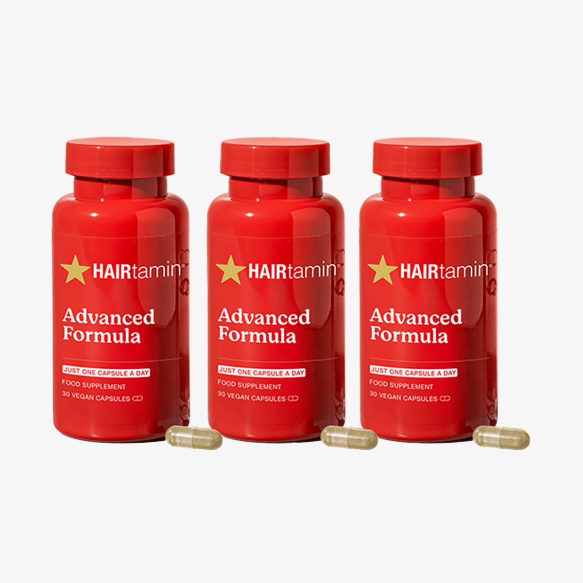 Drei Flaschen „HAIRtamin Advanced Formula“ im 3-Monats-Paket mit hellbraunen Kapseln im Vordergrund vor einem weißen Hintergrund.