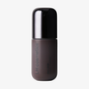 Ein mattbrauner und schwarzer „Ctrl+ SKIN“-Foundation-Flakon von LH Cosmetics vor einem schlichten weißen Hintergrund.