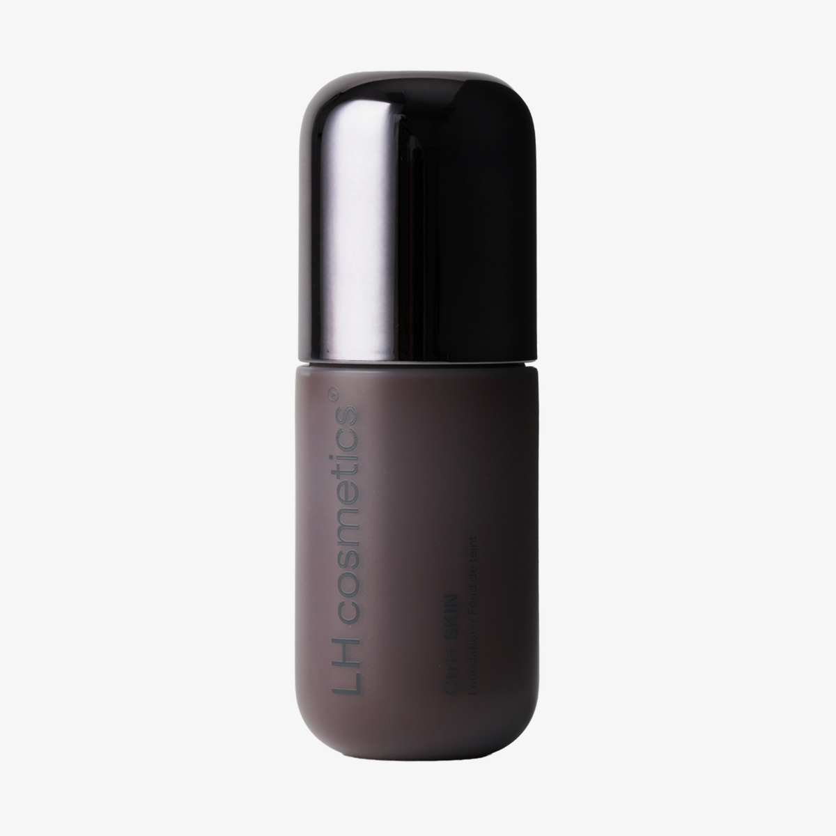 Ein mattbrauner und schwarzer „Ctrl+ SKIN“-Foundation-Flakon von LH Cosmetics vor einem schlichten weißen Hintergrund.