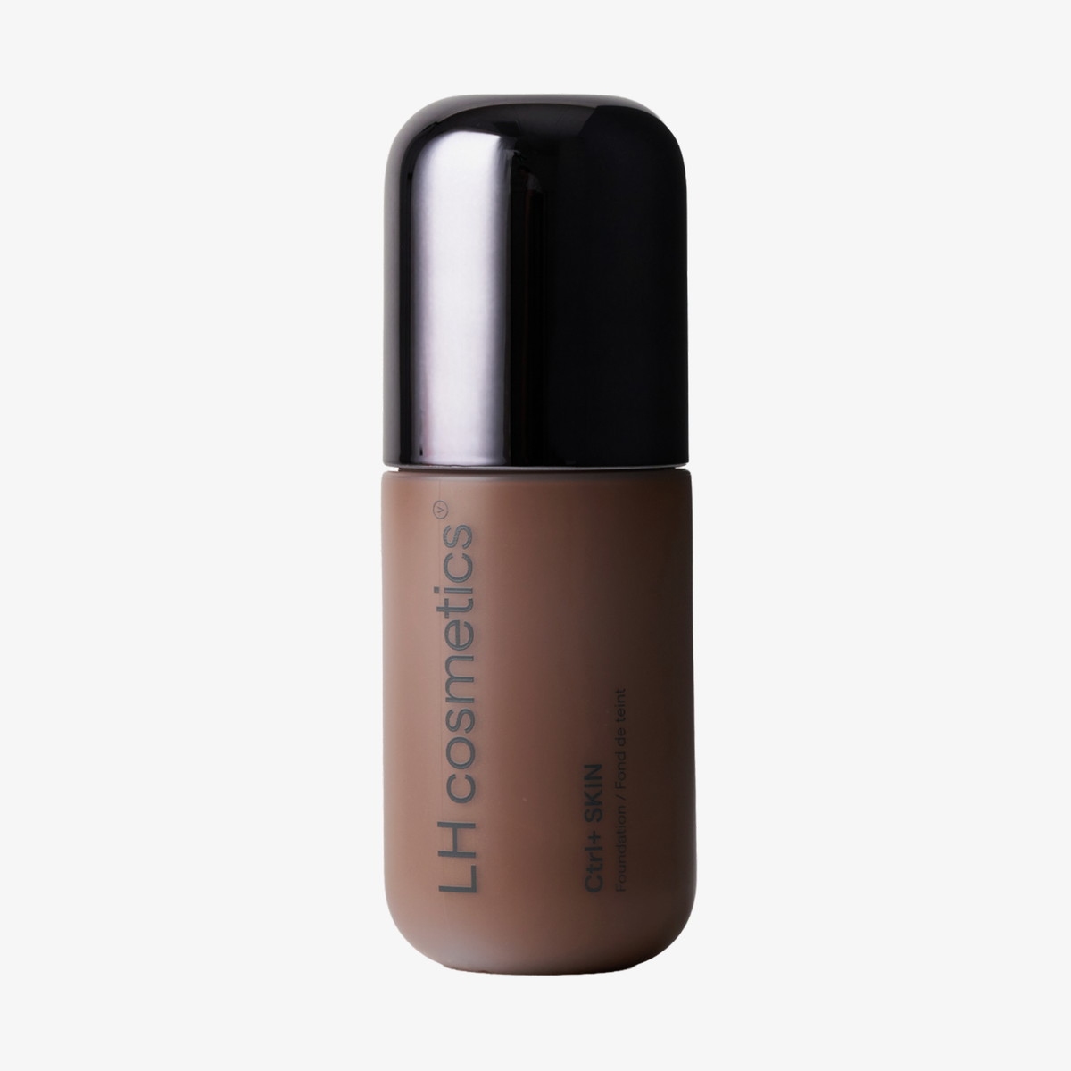 Eine braune Flasche der „Ctrl+ SKIN“-Foundation von LH Cosmetics mit schwarzem Verschluss steht aufrecht auf einem weißen Hintergrund.