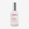 Transparente Sprühflasche mit silbernem Deckel, gefüllt mit MERME Antioxidant Mist mit Rosenquarz und sichtbaren Rosenquarzkristallen am Flaschenboden.