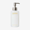 Eine weiße Pumpflasche mit der Aufschrift MERME Delicate Dissolve Face Cleanser ist auf einem einfarbigen Hintergrund abgebildet.