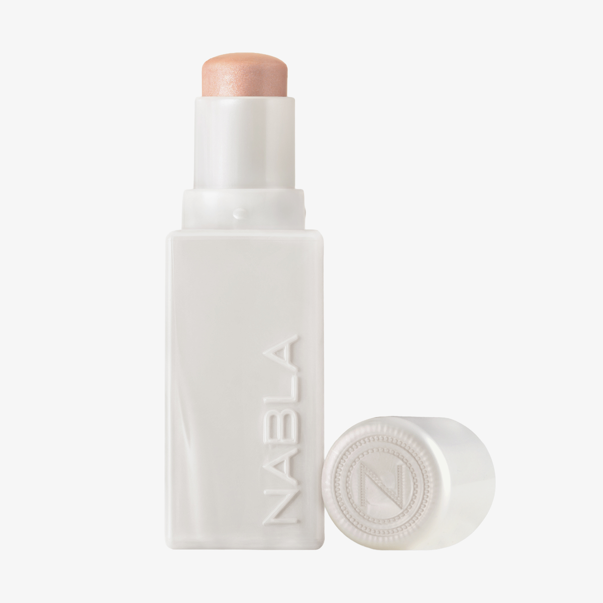Eine weiße Tube des „Art Of Skin Glazing Stick“ von NABLA Cosmetics, deren Verschluss entfernt wurde, gibt den Blick auf den schimmernden Highlighter im Inneren frei.