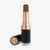 Eine Tube NABLA Cosmetics Beyond Jelly Lipstick Perlati Crystal Chestnut in Dunkelbraun, mit einer schwarz-goldenen Hülle und Kappe.