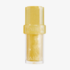 Lip Candy Oil Banana von NABLA Cosmetics mit gelb-glitzerndem Verschluss und funkelndem Inhalt vor weißem Hintergrund.