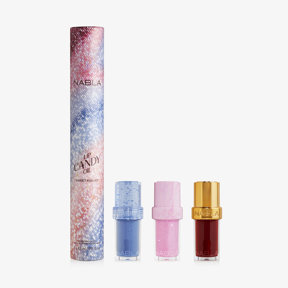 Drei bunte Lip Candy Oil-Tuben und eine gemusterte Sweet Kiss Kit-Box von NABLA Cosmetics auf weißem Hintergrund.