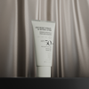 NERDS. Leichte Hydrate UV Defense Lotion SPF50 auf einem seidig-beigen Hintergrund.