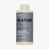 Eine Flasche OLAPLEX N°4 CURLBond Shaper Hydrating Curl Shampoo mit grauem Etikett und schwarzer Beschriftung.