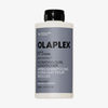 Eine Flasche OLAPLEX N°5 CURL Bond Shaper Hydrating Curl Conditioner mit grauem Etikett und schwarzem Verschluss.